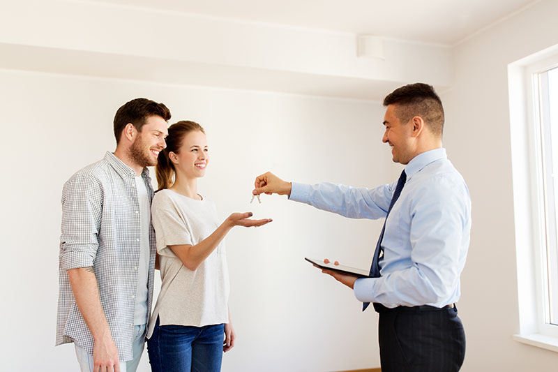 a realtor giving keys to a home buyers with an Accepted Home Offer