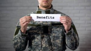 veteran holding a benefits sign